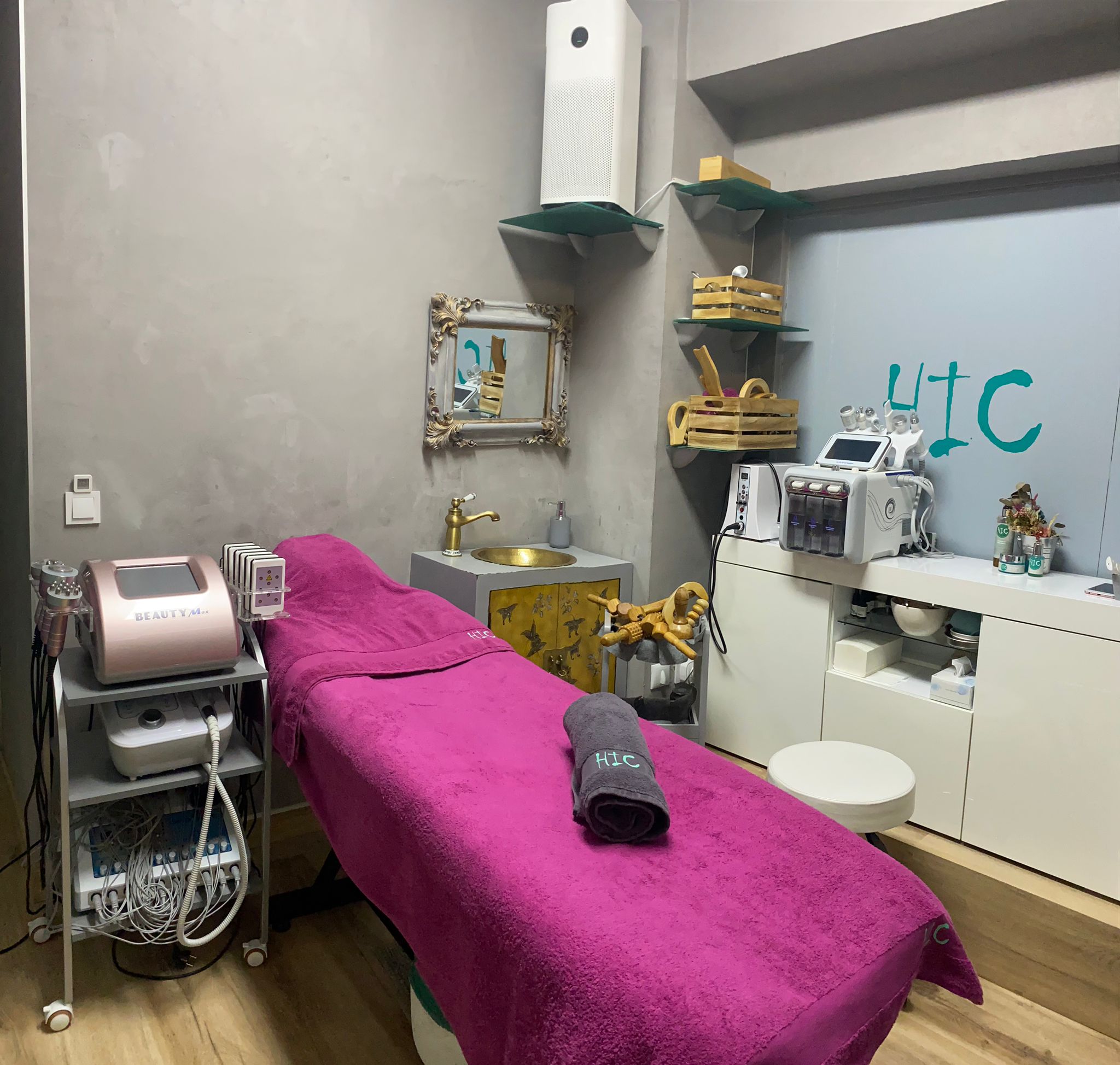Cabina real de HIC con camilla cubierta en fucsia, lavabo y equipos de estética